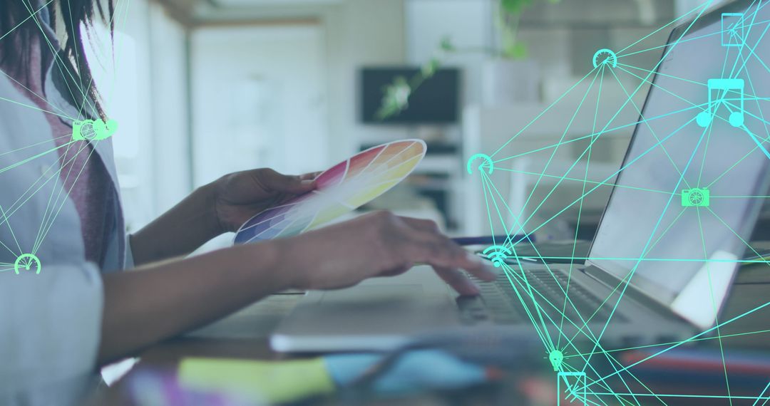 Creative Professional Using Color Palette and Laptop in Connected Workspace