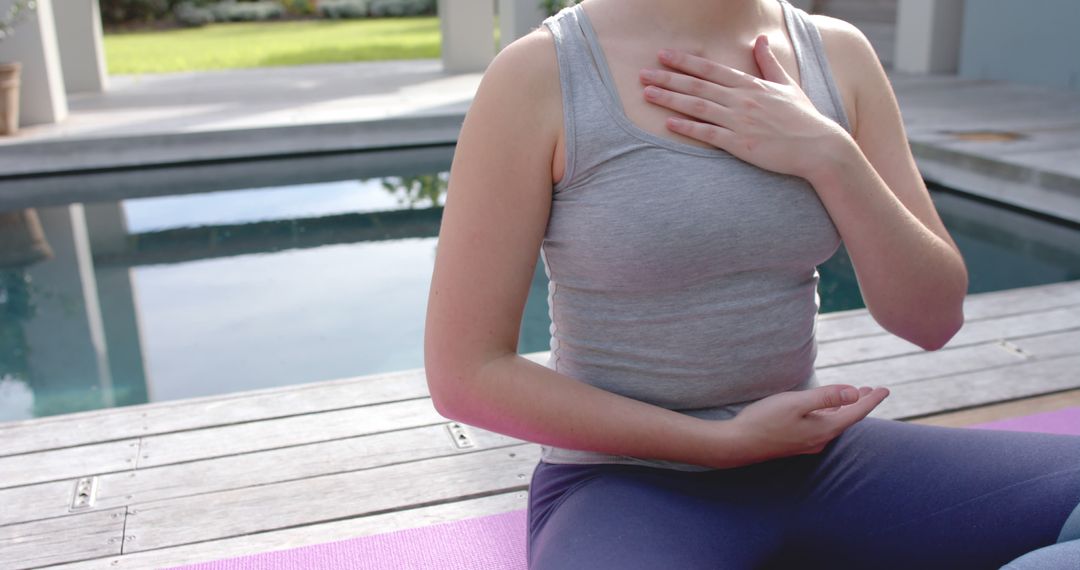 Caucasian Woman Meditating by Pool in Serene Garden - Free Images, Stock Photos and Pictures on Pikwizard.com