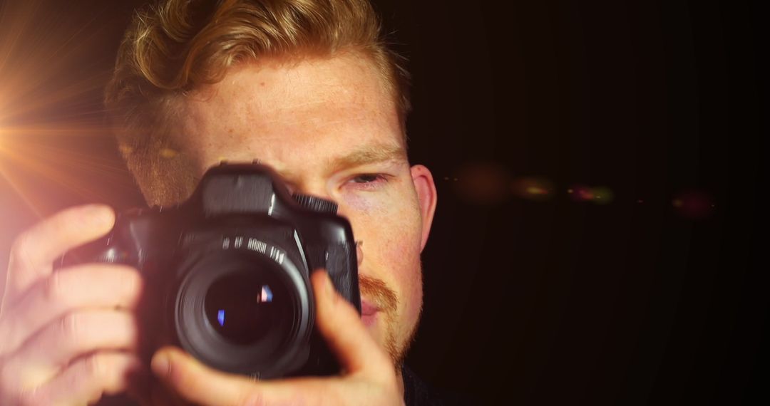 Male Photographer in Action with Camera and Lens Flare