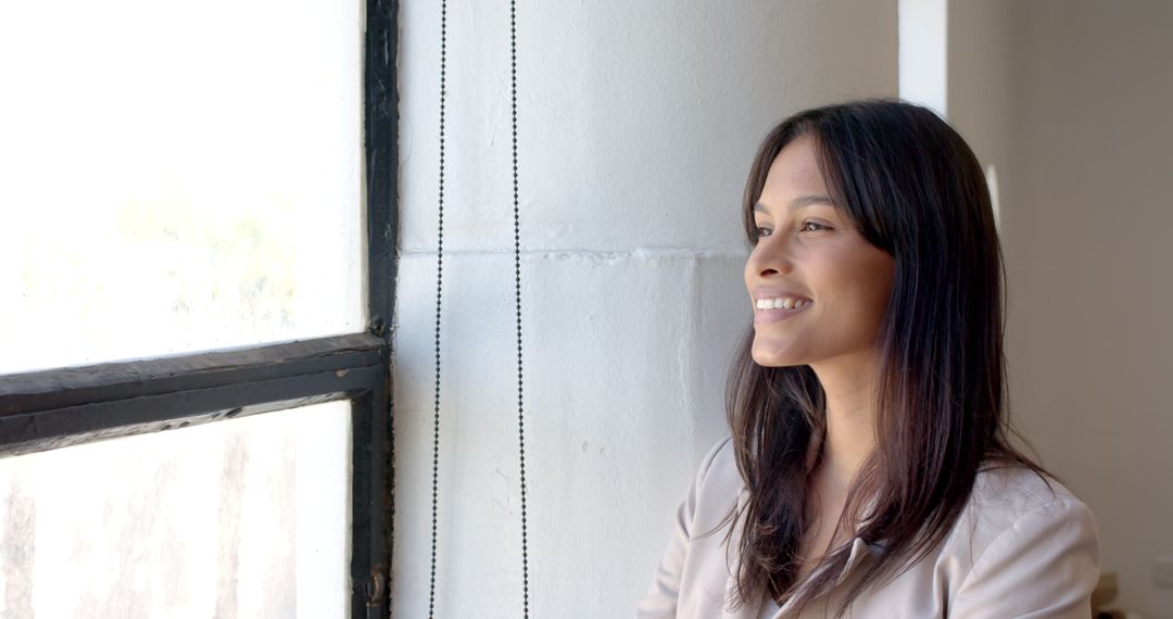 Smiling Businesswoman Looking Out Window for a Relaxing Work Break