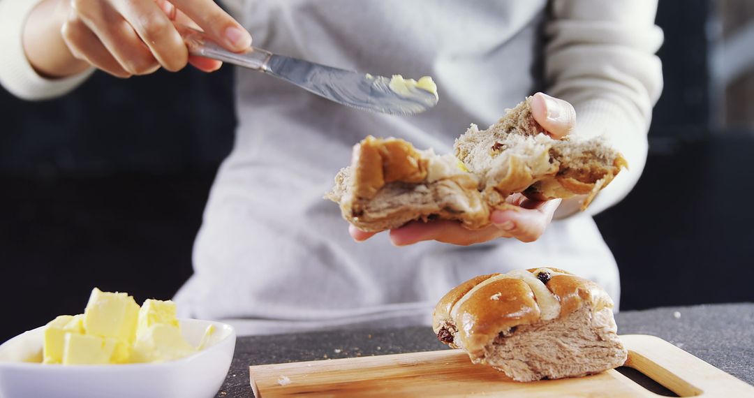 Person Spreading Butter on Fresh Hot Cross Bun - Free Images, Stock Photos and Pictures on Pikwizard.com