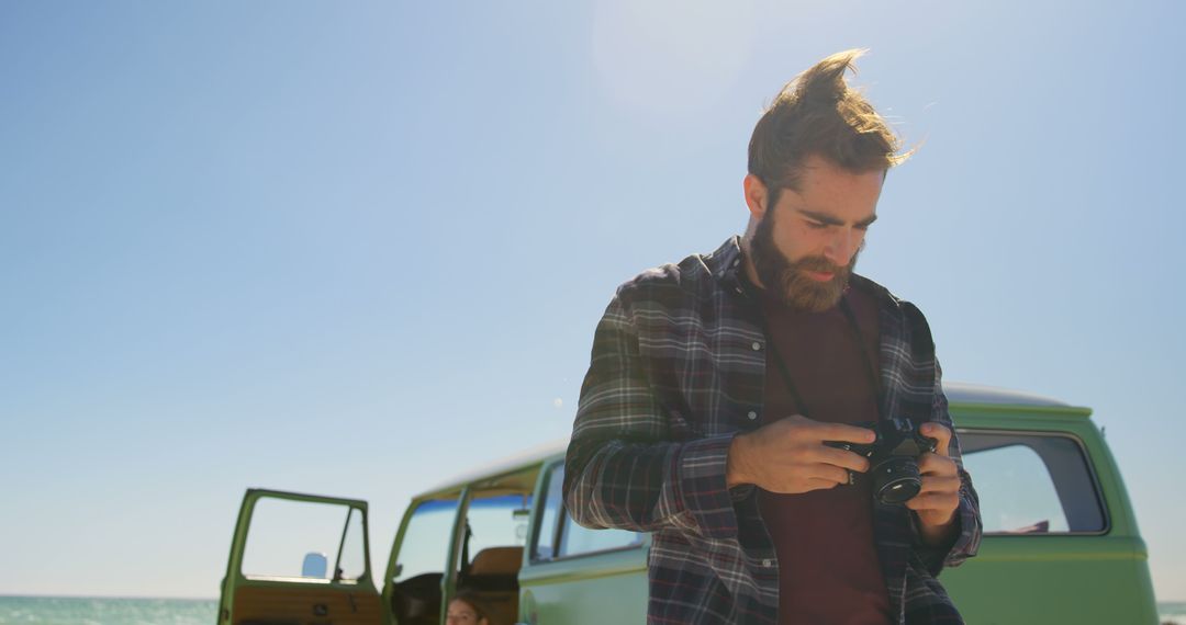 Young Bearded Man with Camera on Beach beside Vintage Van - Free Images, Stock Photos and Pictures on Pikwizard.com