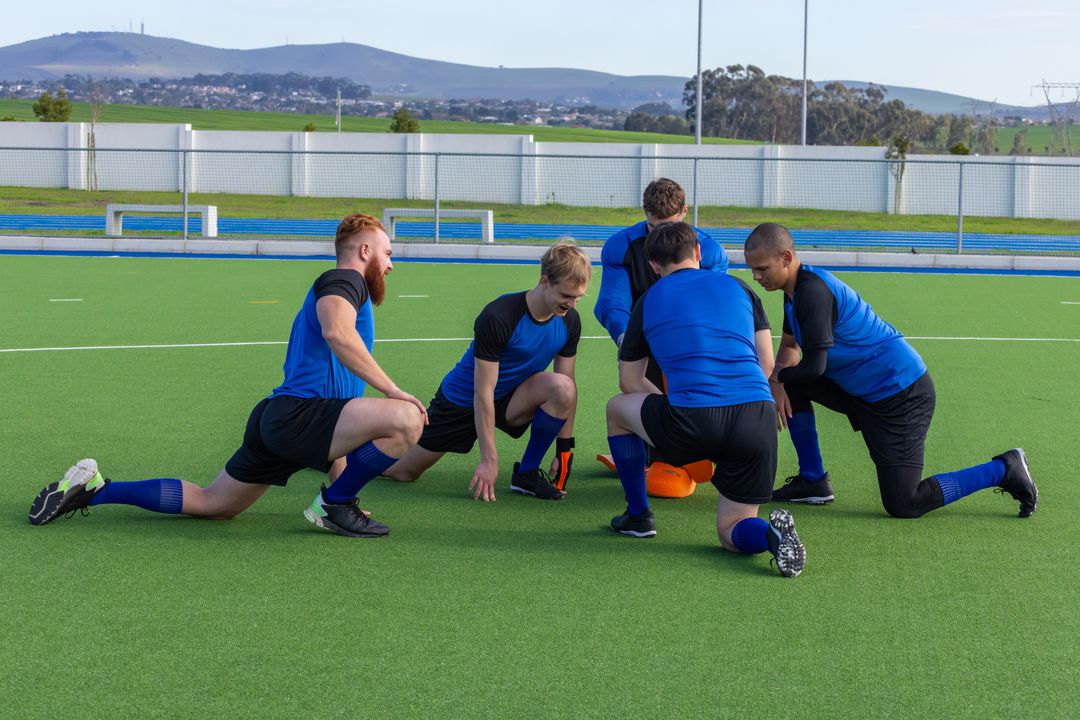 Dynamic Sports Team Strategizing in Blue Uniforms on Turf Field