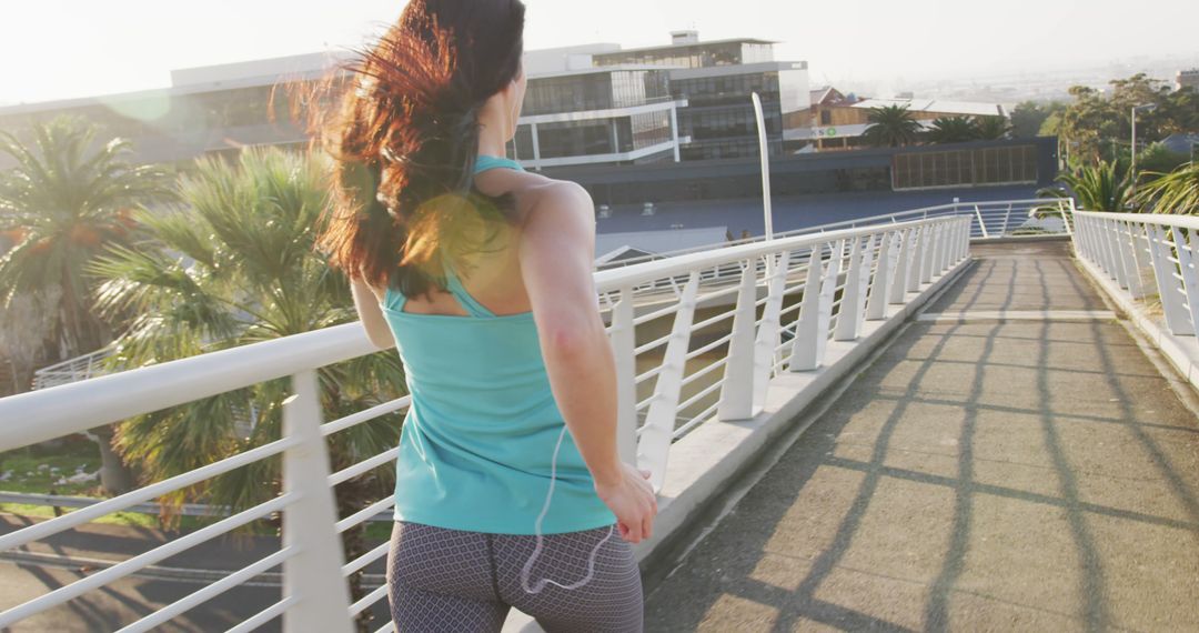 Woman Jogging on Urban Bridge in Morning Sunlight - Free Images, Stock Photos and Pictures on Pikwizard.com