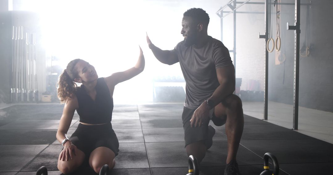 Diverse Trainer and Client Sharing High-Five in Ambient Fitness Studio