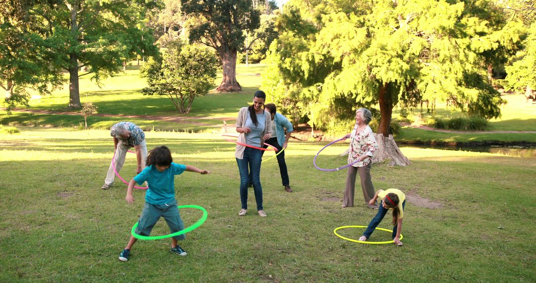 Family Bonding with Hula Hoops in Park on Sunny Day - Free Images, Stock Photos and Pictures on Pikwizard.com