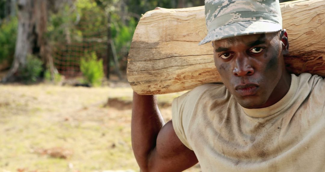 Strong Military Man Engaged in Intense Log Carrying Exercise