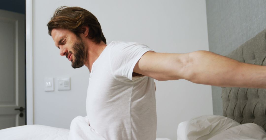 Man Stretching in Bed After Waking Up with Morning Light - Free Images, Stock Photos and Pictures on Pikwizard.com