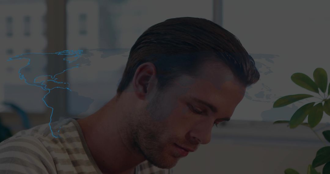 Focused Professional with Digital World Map Overlay in Modern Office
