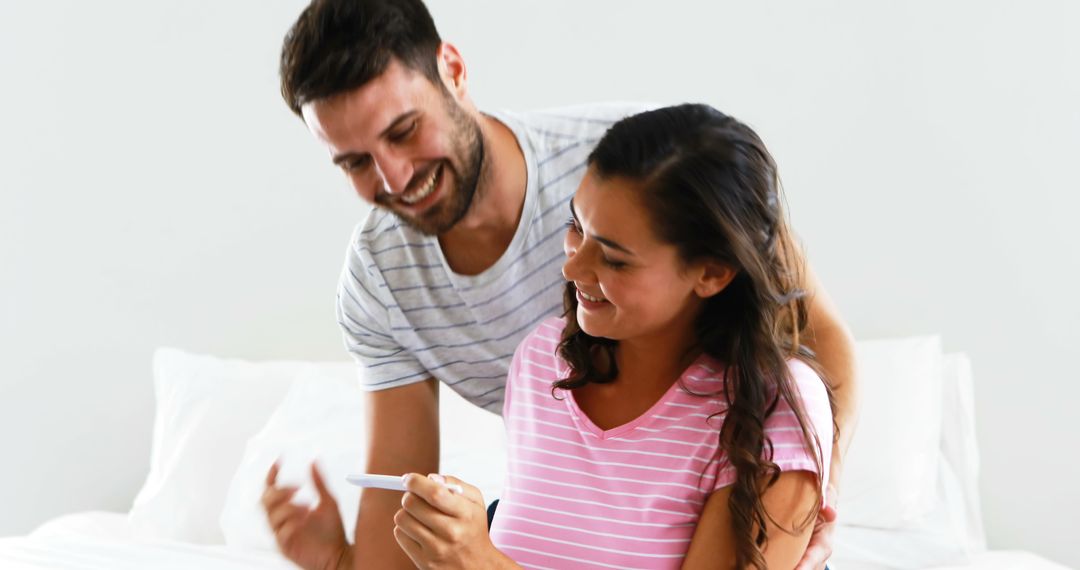 Couple Smiling While Looking at Pregnancy Test - Free Images, Stock Photos and Pictures on Pikwizard.com