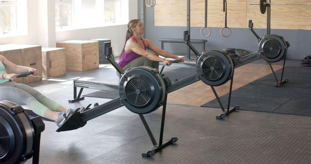 Women Exercising at Gym on Rowing Machines - Free Images, Stock Photos and Pictures on Pikwizard.com