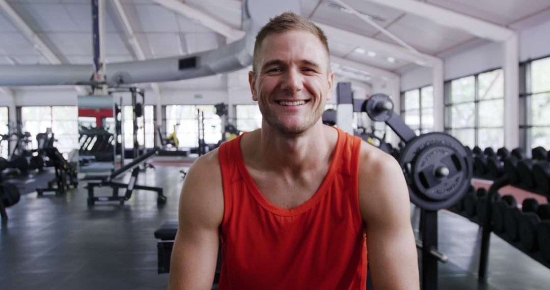 Happy Young Man Posing at Gym in Red Tank Top - Free Images, Stock Photos and Pictures on Pikwizard.com