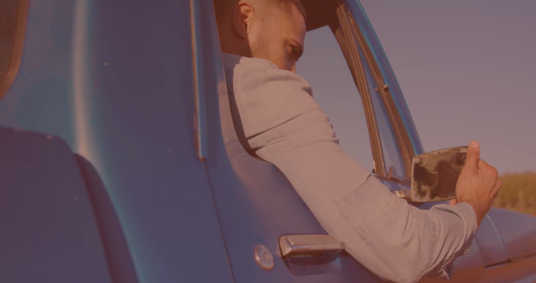 Man Preparing for Road Trip Adjusting Car Mirror