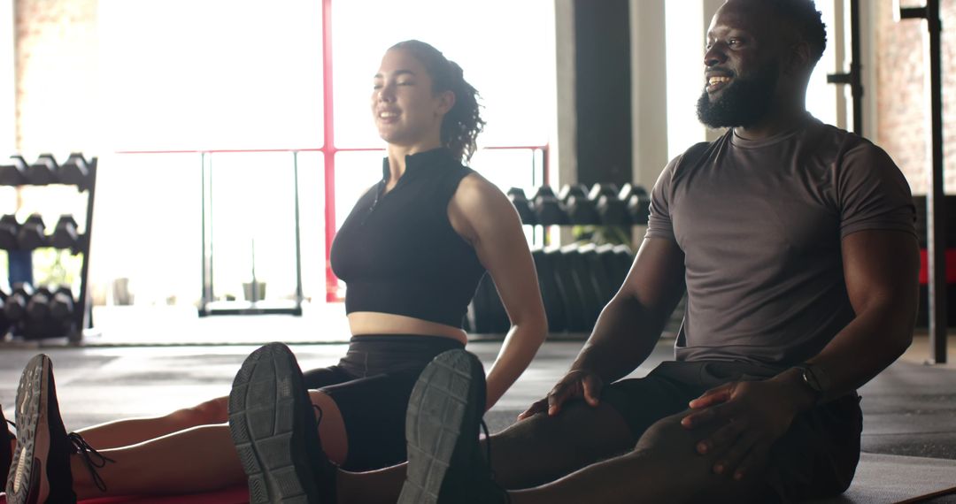 Diverse Fitness Partners Stretching on Exercise Mats in Gym