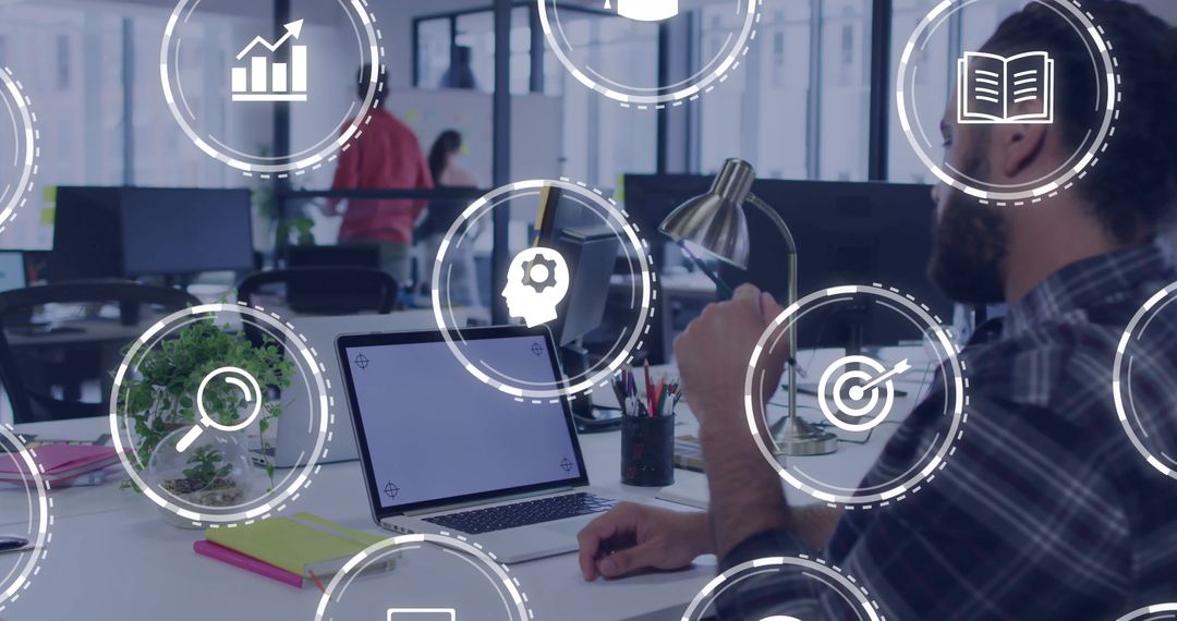 Man Working on Laptop with Technology Icons in Modern Office