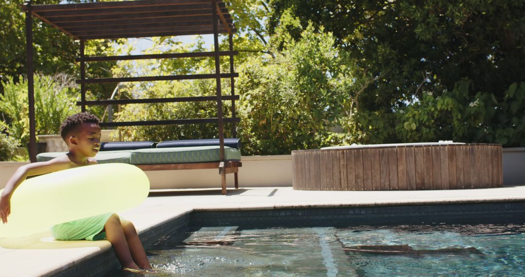 Happy Boy Enjoying Bright Day at the Pool with Inflatable