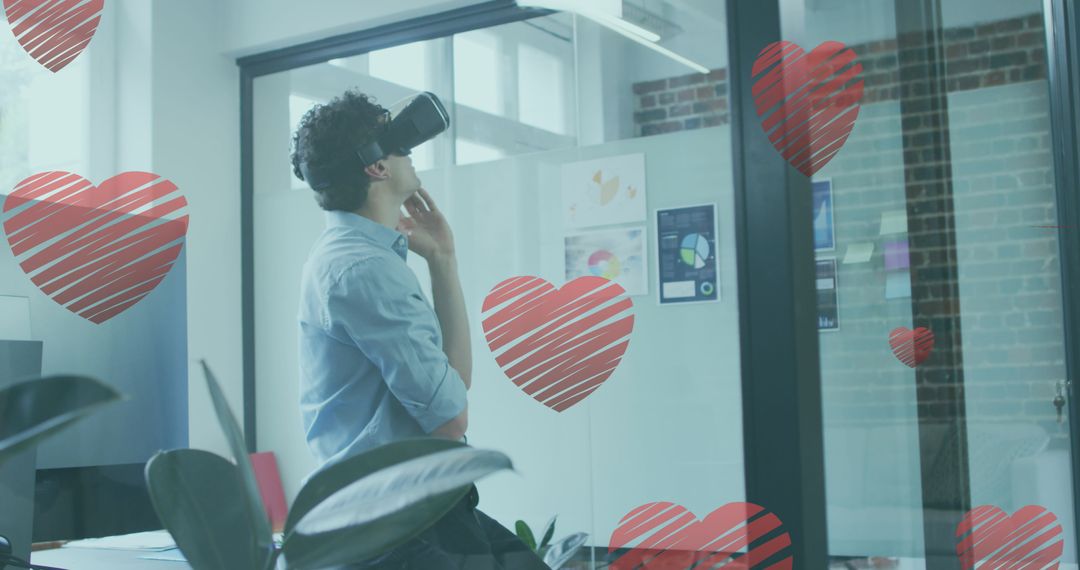 Man Using VR Headset in Modern Office with Love Heart Illustrations - Free Images, Stock Photos and Pictures on Pikwizard.com