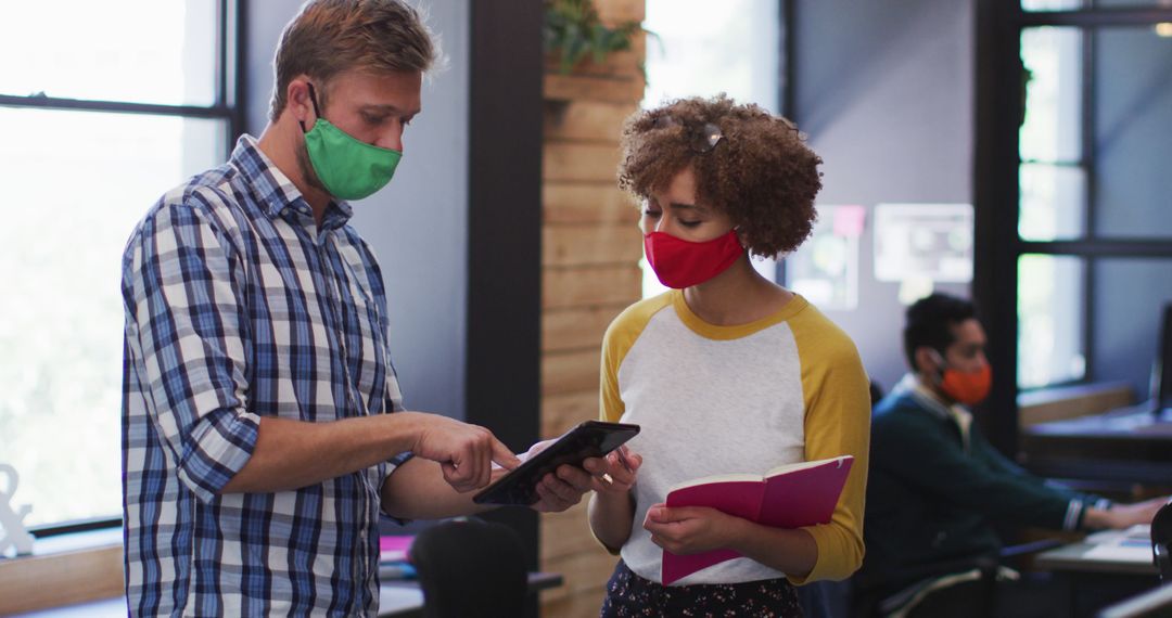 Colleagues Discussing Project Wearing Masks in Modern Office