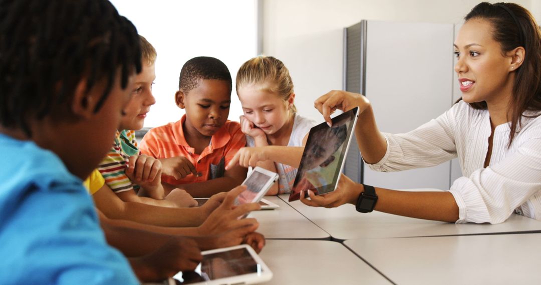 Teacher Guiding Diverse Group of Students with Digital Tablets in Classroom - Free Images, Stock Photos and Pictures on Pikwizard.com