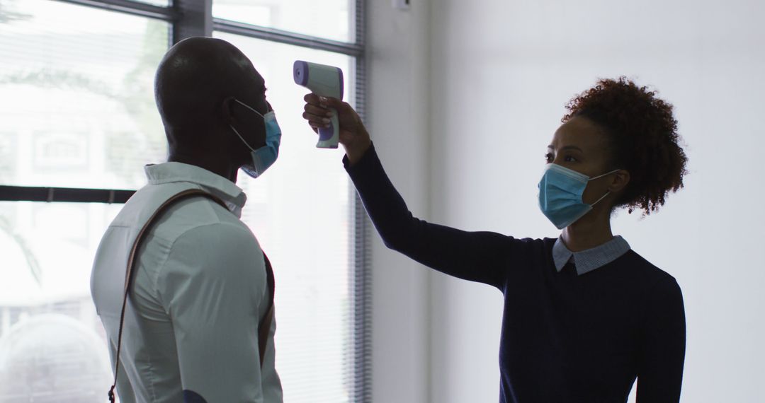 Healthcare Worker Taking Temperature of Man in Face Mask - Free Images, Stock Photos and Pictures on Pikwizard.com