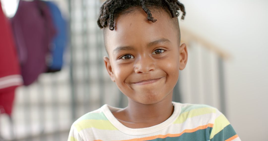 Joyful Boy with Twists Smiling Indoors in Striped Shirt