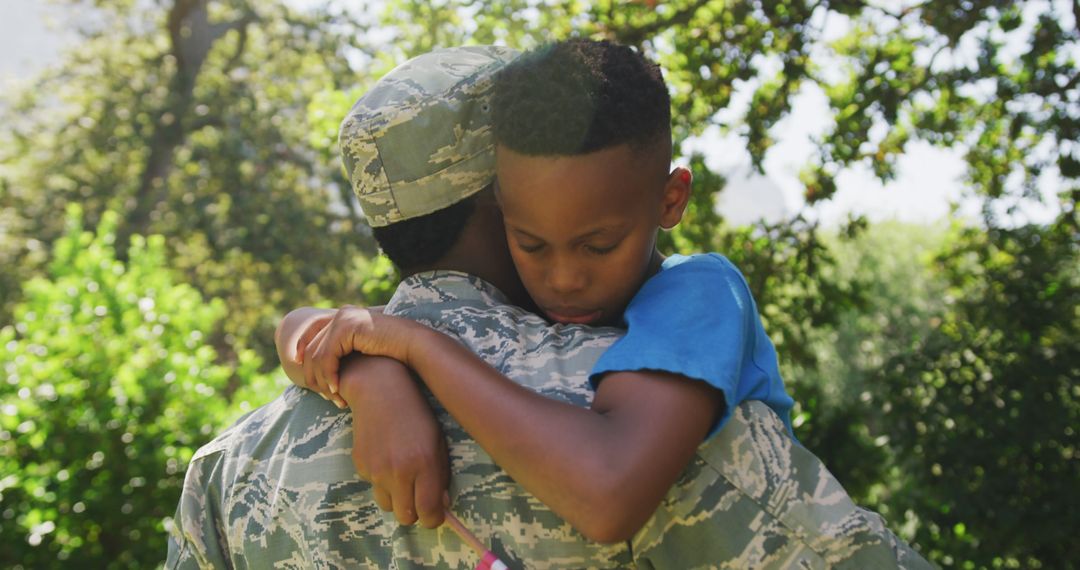Returning African American Soldier Embracing Son in Garden