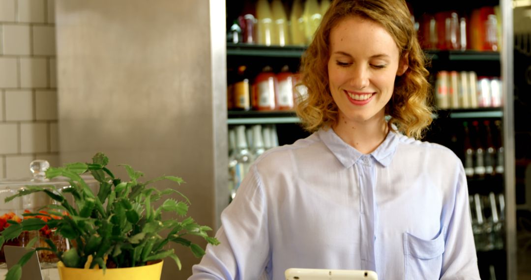 Woman Smiling and Using Tablet in Cafe - Free Images, Stock Photos and Pictures on Pikwizard.com