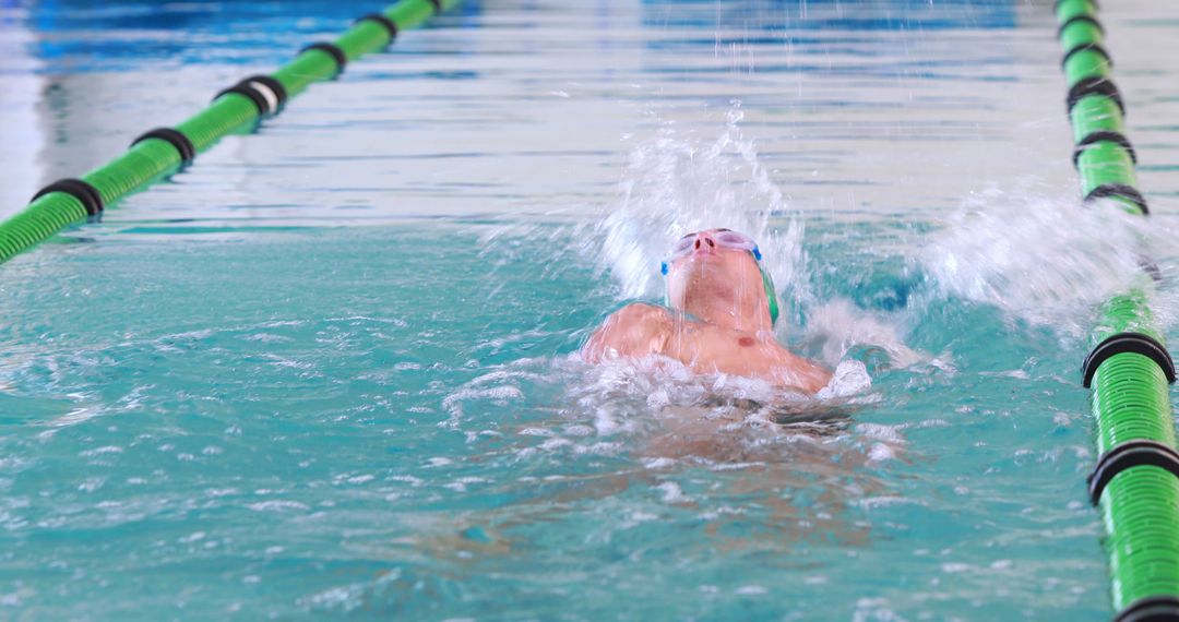 Young Male Swimmer Performing Backstroke in Indoor Pool - Free Images, Stock Photos and Pictures on Pikwizard.com