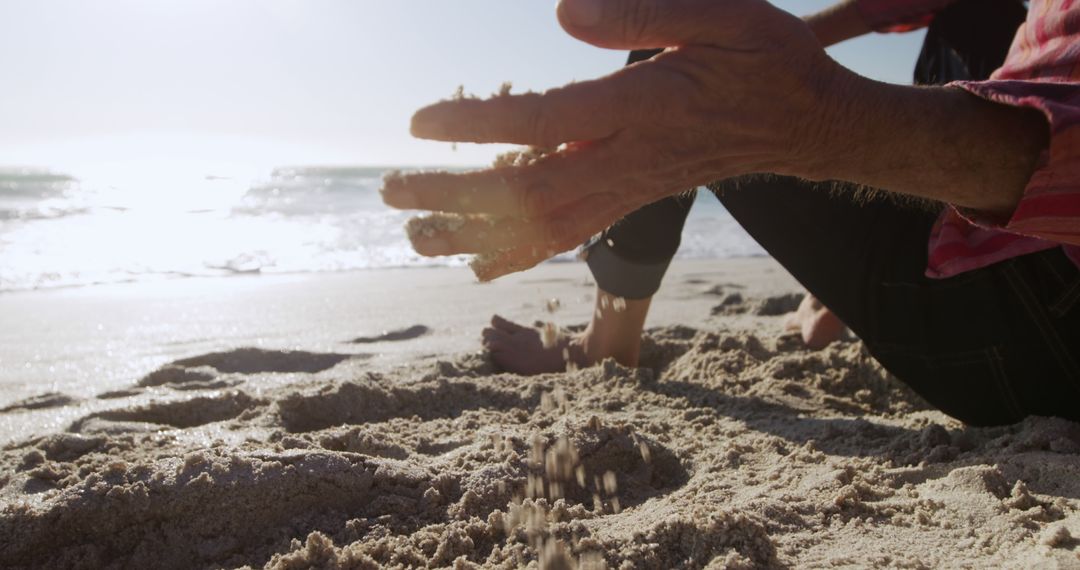 Person Dropping Sand on Sunny Beach with Ocean Horizon - Free Images, Stock Photos and Pictures on Pikwizard.com