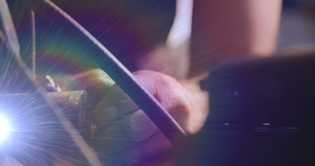 Mechanic's Hands Repairing Vehicle with Illuminating Light Beam