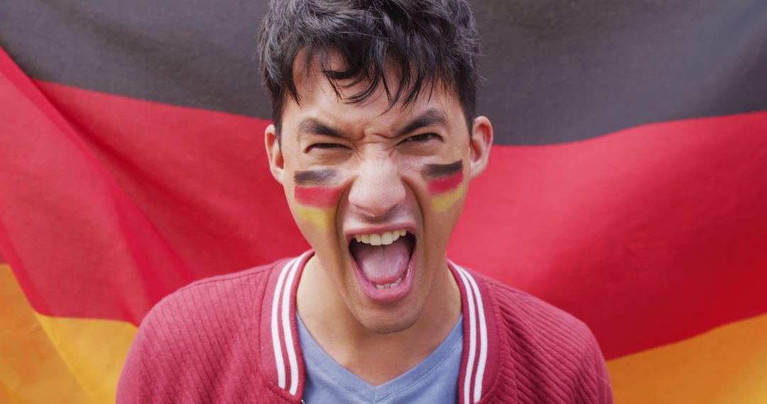 Portrait of happy biracial man with flag of germany in background and on cheek - Free Images, Stock Photos and Pictures on Pikwizard.com