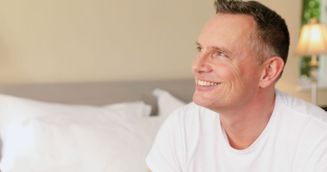 Smiling Middle-Aged Man Relaxing in Bedroom - Free Images, Stock Photos and Pictures on Pikwizard.com