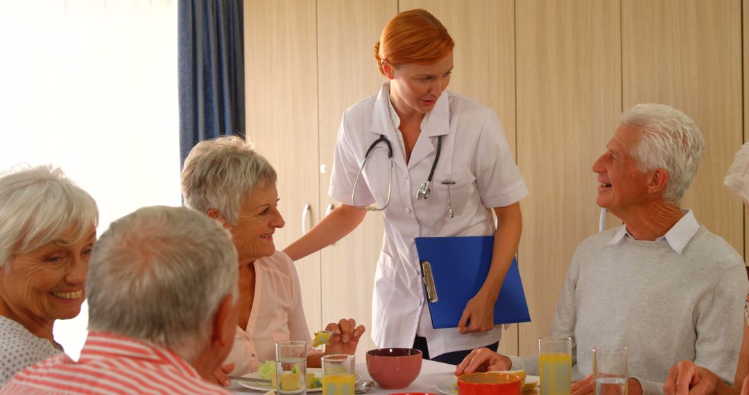 Nurse Interacting with Senior Citizens During Meal Time - Free Images, Stock Photos and Pictures on Pikwizard.com