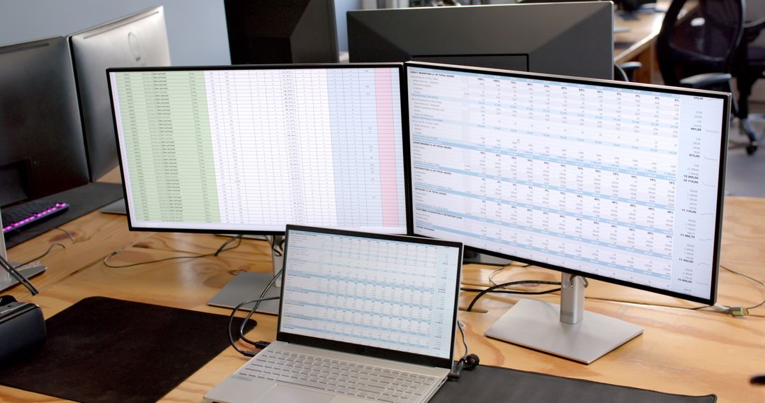 Multiple Screens Displaying Financial Data in Office Workspace