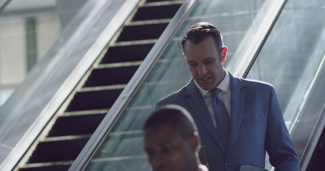 Businessman in Formal Suit Riding Escalator in Office Building - Free Images, Stock Photos and Pictures on Pikwizard.com