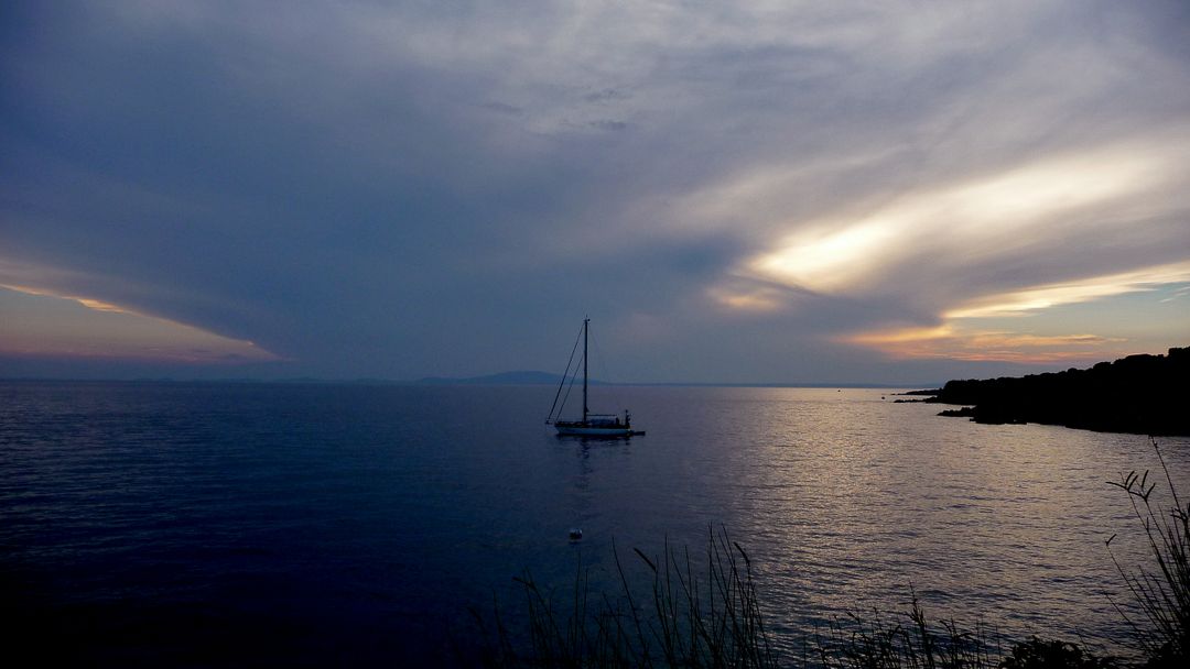 Tranquil Sunset Over Calm Sea with Single Sailboat - Free Images, Stock Photos and Pictures on Pikwizard.com