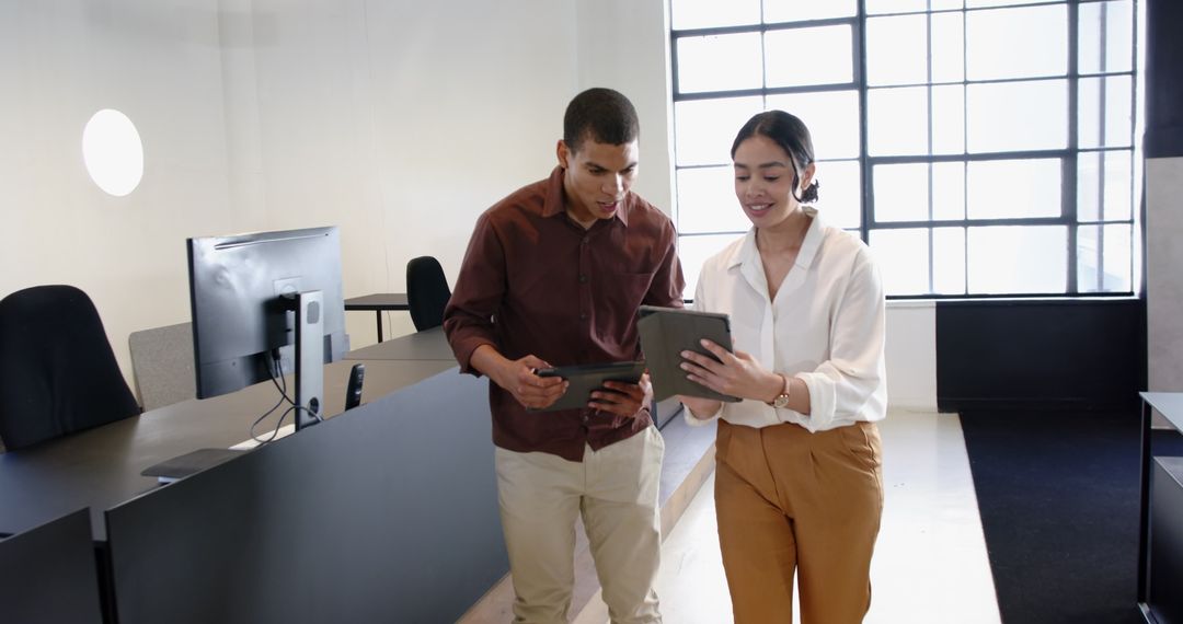 Colleagues Engaging with Technology in Modern Office Space