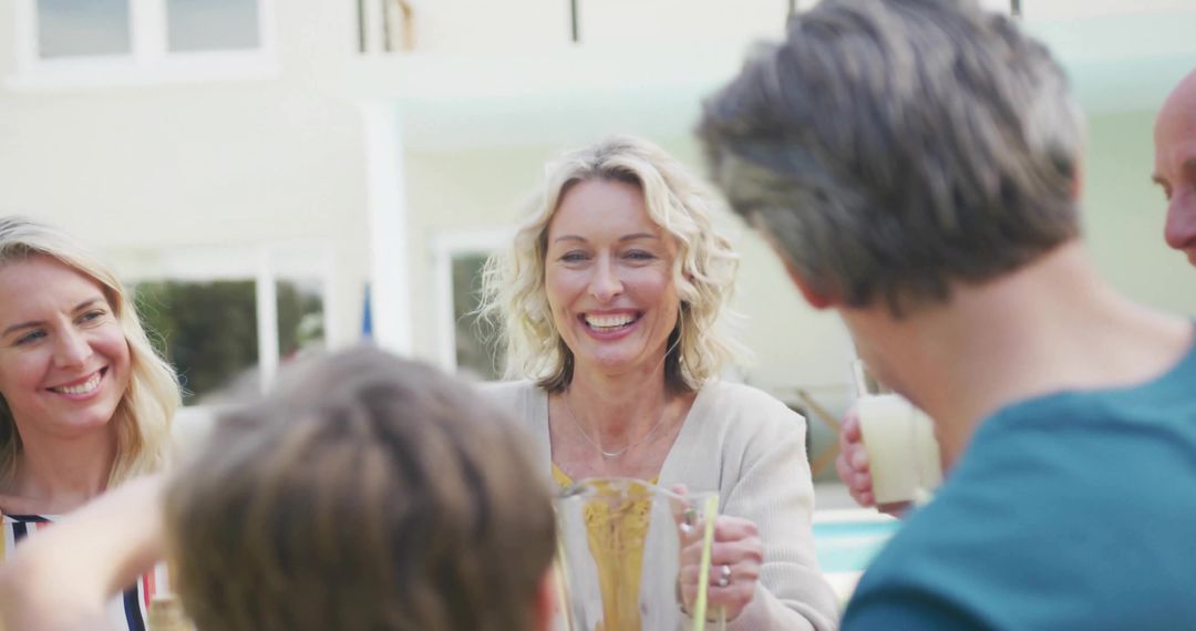 Smiling Family Enjoying Refreshments by Poolside Patio