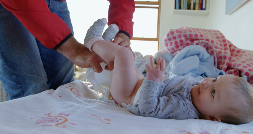 Parent Changing Baby Diaper in Nursery - Free Images, Stock Photos and Pictures on Pikwizard.com