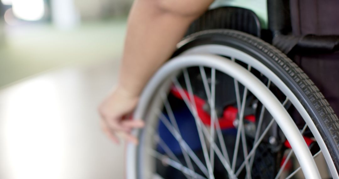 Close-Up of Hand Gripping Wheel on Wheelchair for Mobility Concept