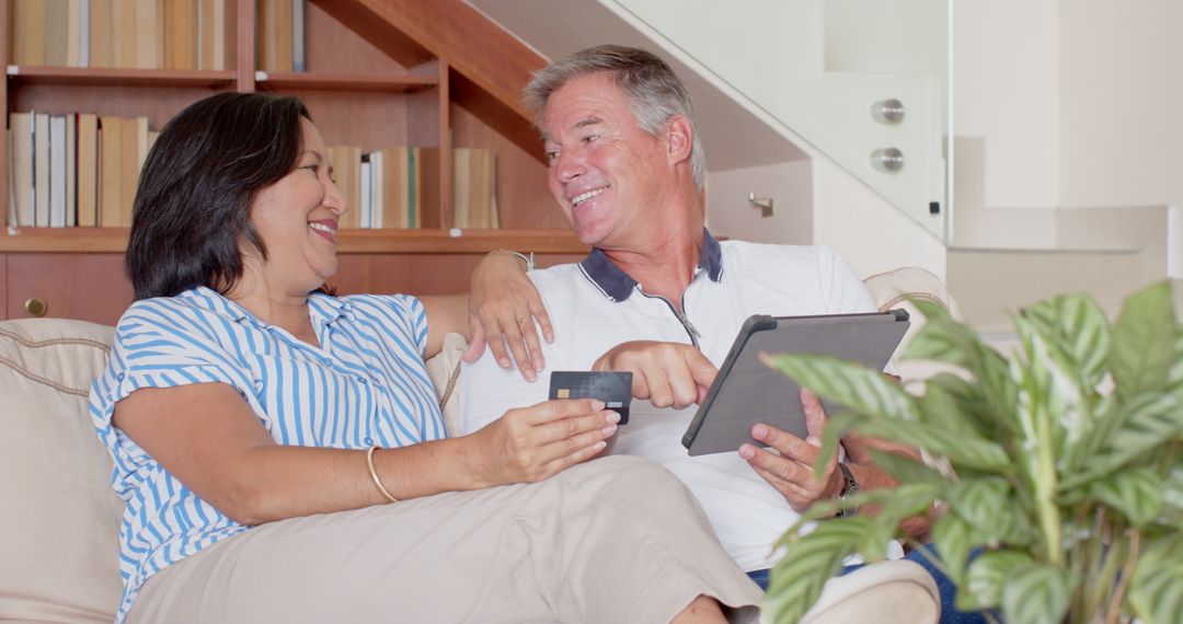 Senior Couple Relaxing with Tablet and Credit Card at Home