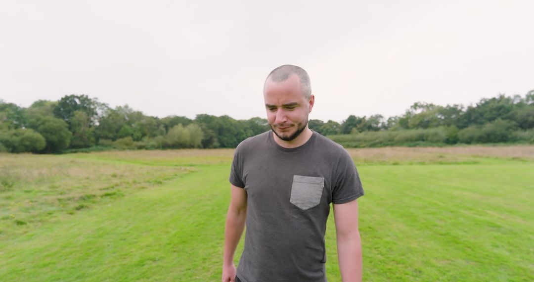 Man Walking on Grassy Plain Enjoying Nature and Contemplating