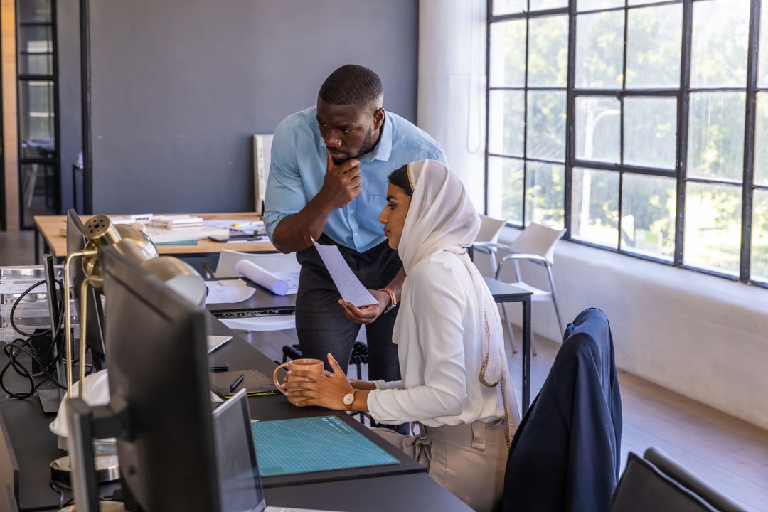 Collaborative Team Analyzing Blueprint Ideas in Modern Office