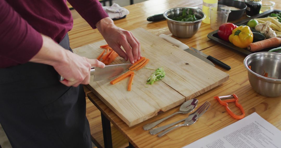 Person Chopping Vegetables on Wooden Cutting Board in Kitchen - Free Images, Stock Photos and Pictures on Pikwizard.com