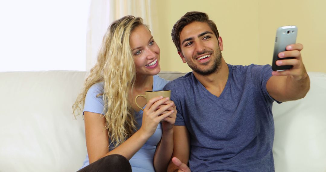 Couple Relaxing on Sofa Taking Selfie with Smartphone