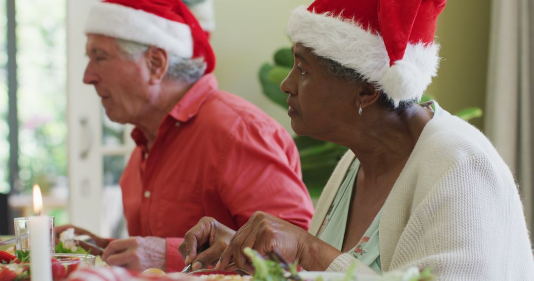 Senior Couple Wearing Santa Hats Enjoying Christmas Meal - Free Images, Stock Photos and Pictures on Pikwizard.com