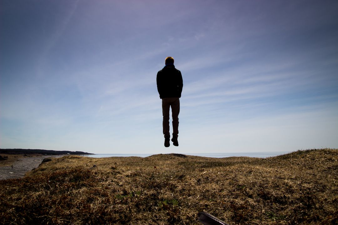 Person Levitating Over Rocky Landscape Under Clear Sky - Free Images, Stock Photos and Pictures on Pikwizard.com