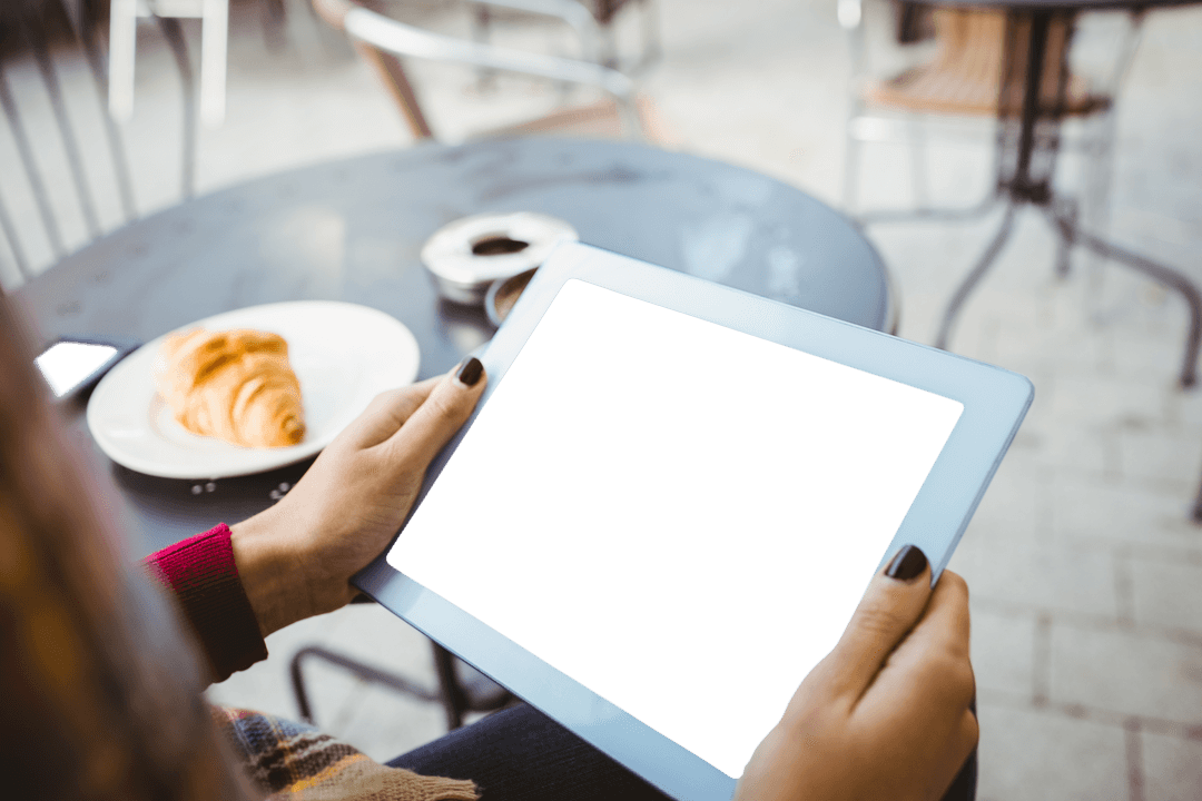 Transparent Screen Tablet Over Breakfast at Outdoor Cafe Table