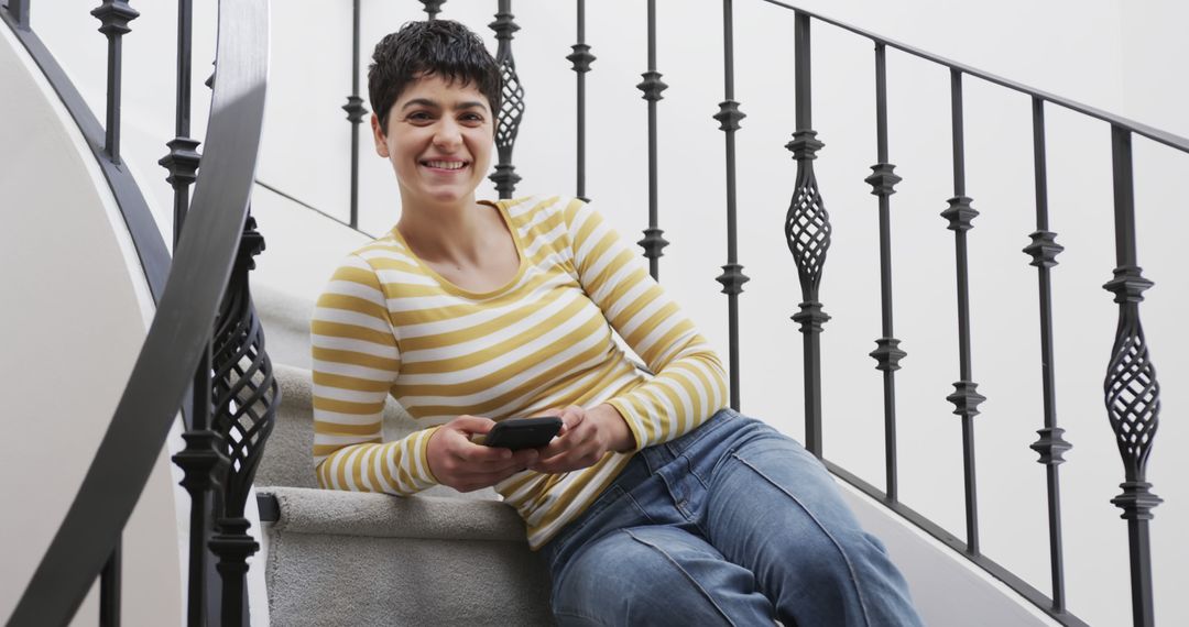 Happy Woman Using Smartphone on Stairs with Iron Railing - Free Images, Stock Photos and Pictures on Pikwizard.com