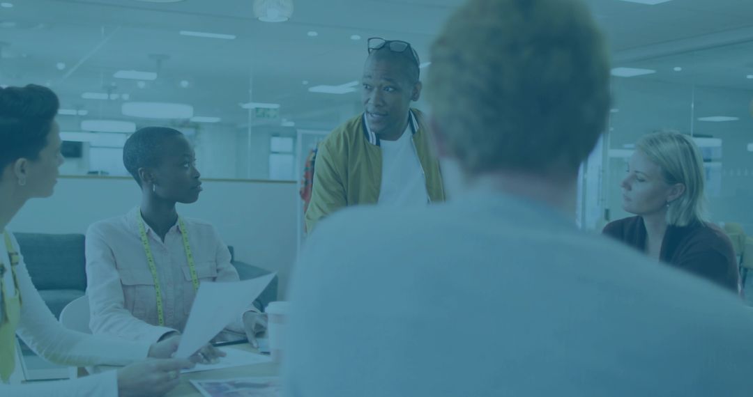 Man Leading Creative Team Meeting in Office While Designers Collaborating and Brainstorming